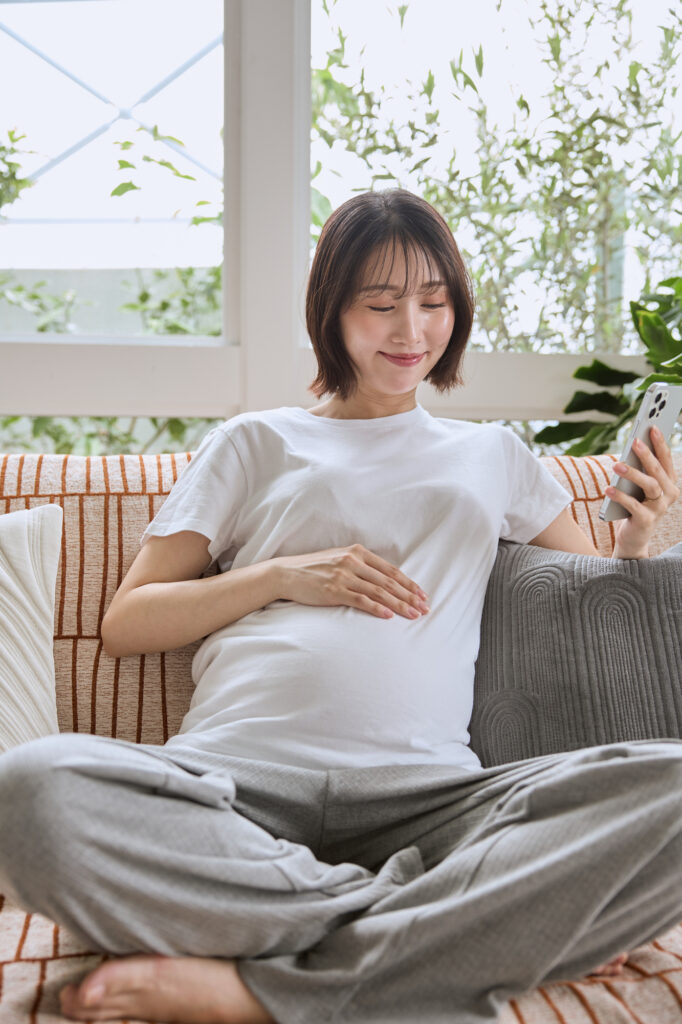 妊娠中にスマホで離乳食の準備を調べる妊婦