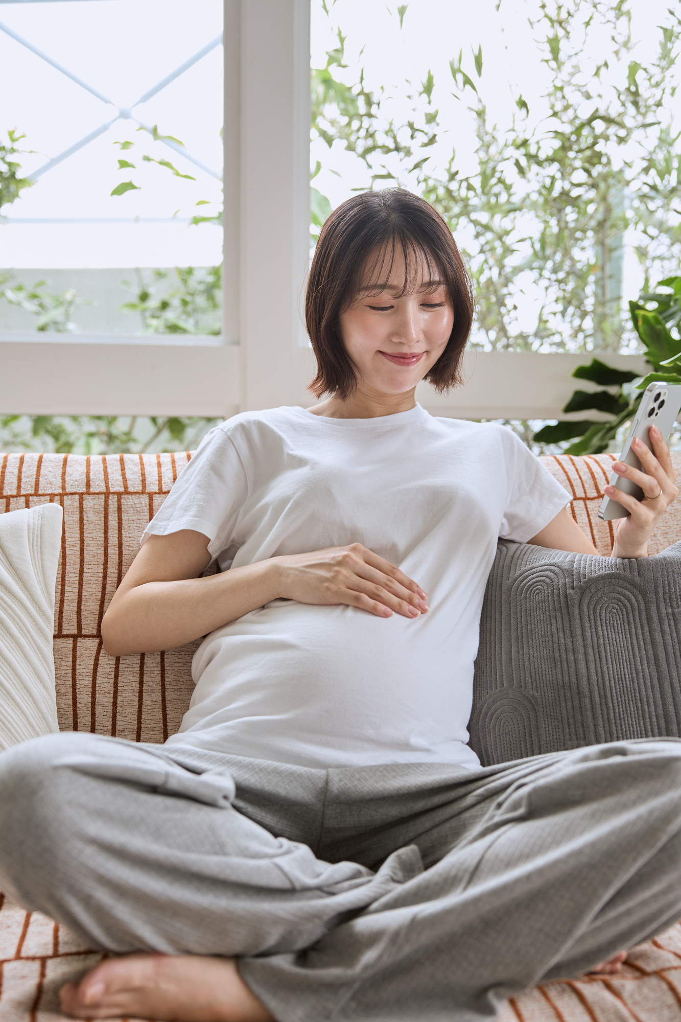 妊娠中にスマホで離乳食の準備を調べる妊婦