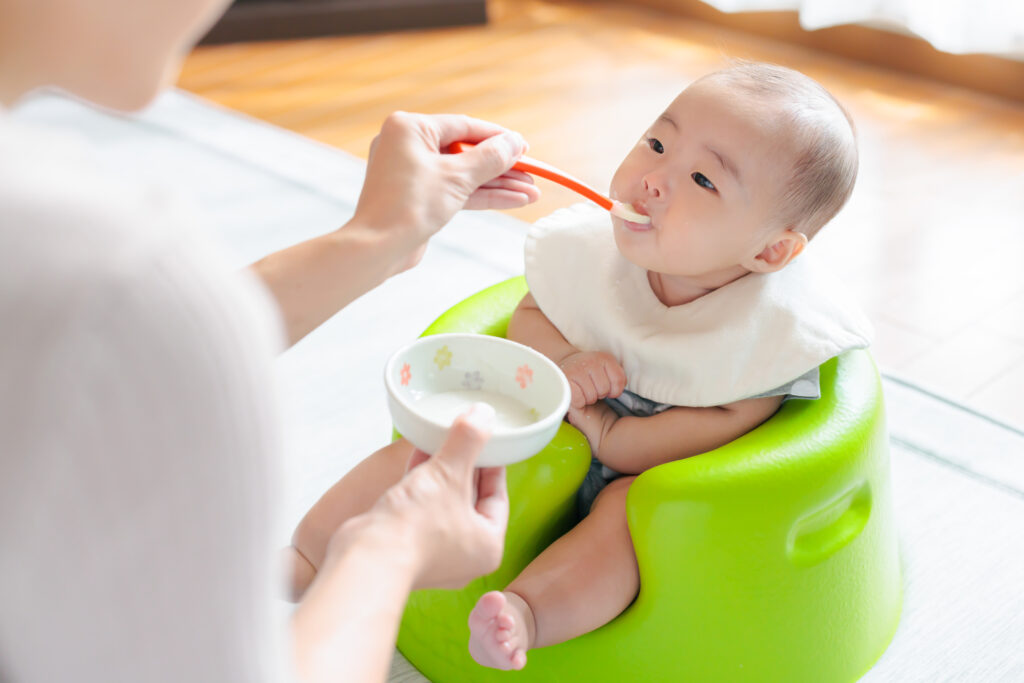 離乳食初期の赤ちゃんがお粥を食べる様子。出汁は6ヶ月頃から使える