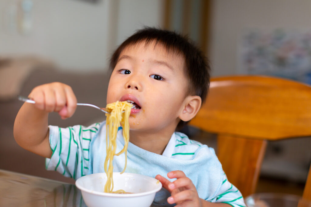 うどんを自分で食べる幼児