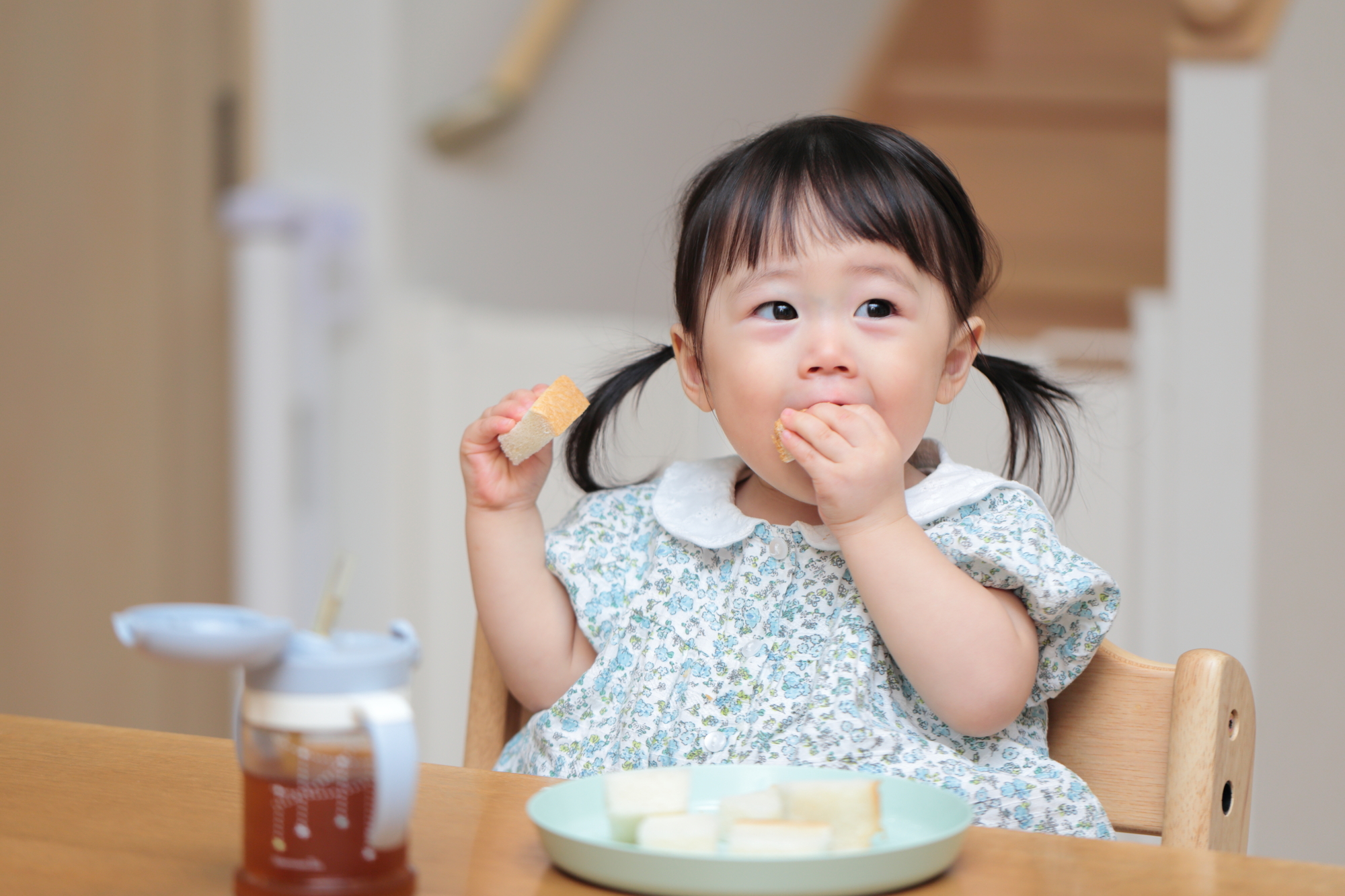 離乳食後期（カミカミ期）にパンを手づかみ食べする女の子
