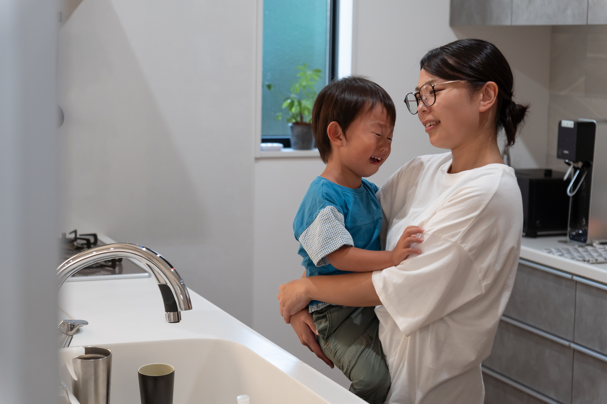 子どもが泣いて食事が進まず困っている親。イヤイヤ期の食卓