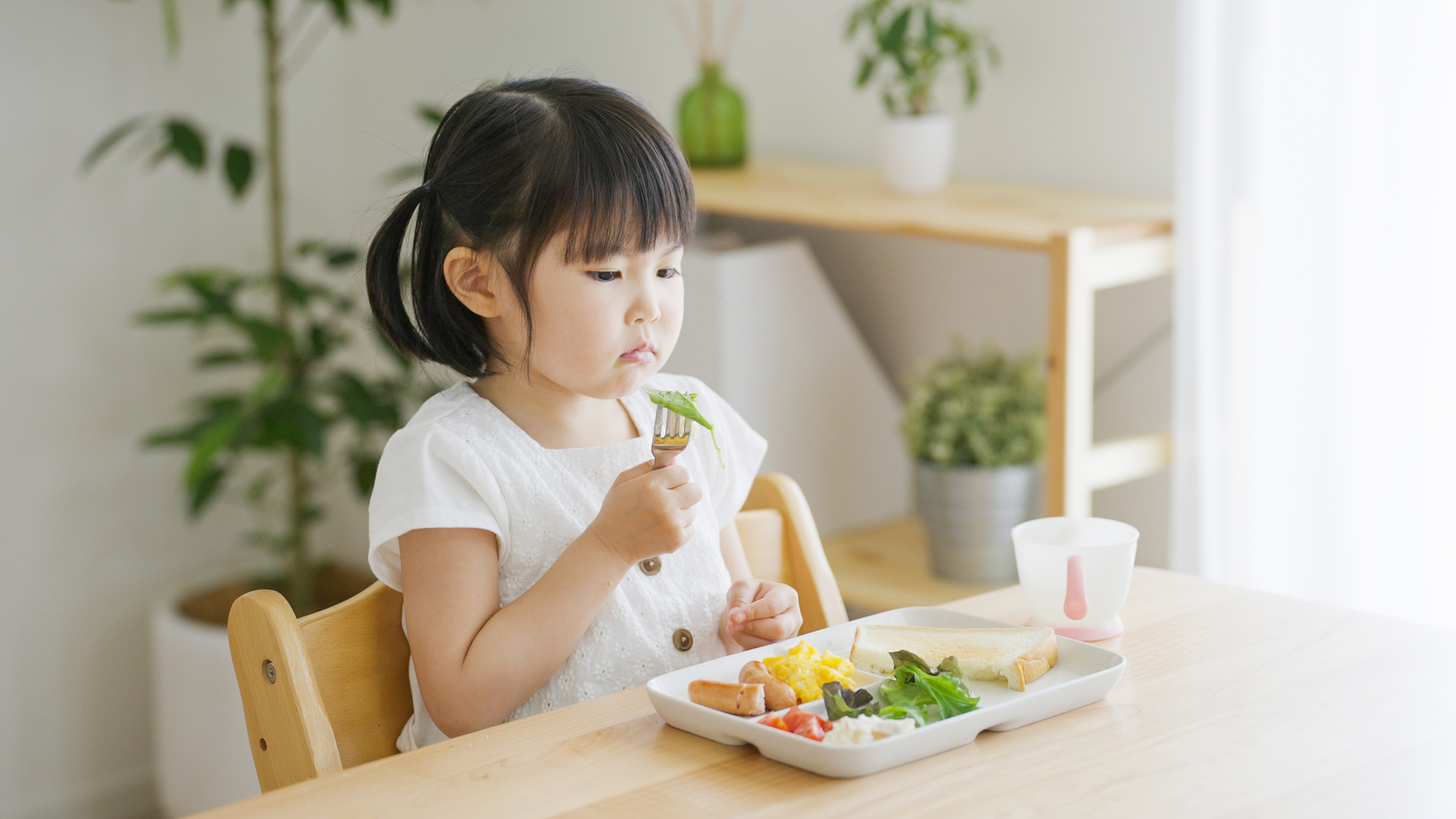 幼児食の量の目安。4歳の子どもが食事をしているところ